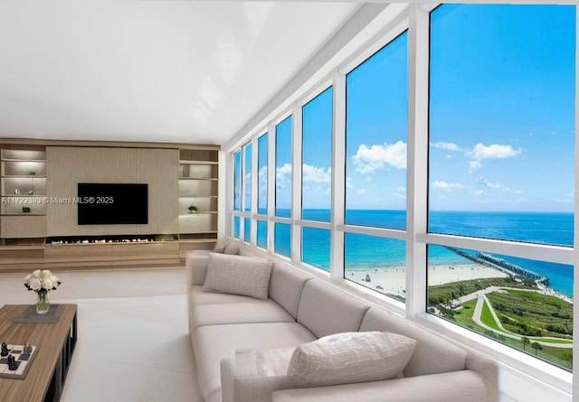 living room featuring built in features, a wealth of natural light, and a water view