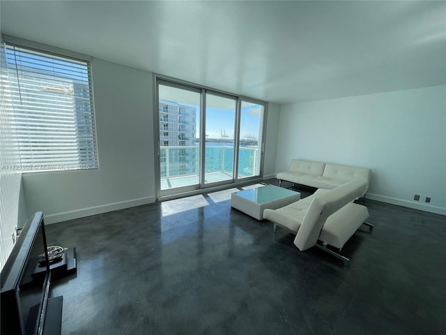 unfurnished living room featuring floor to ceiling windows and a water view