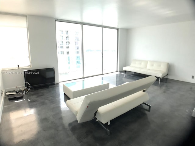 living room with floor to ceiling windows and a healthy amount of sunlight