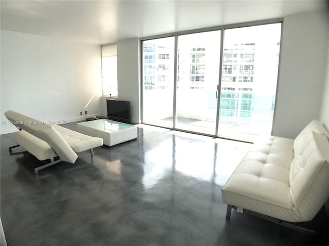 living room with floor to ceiling windows and concrete flooring