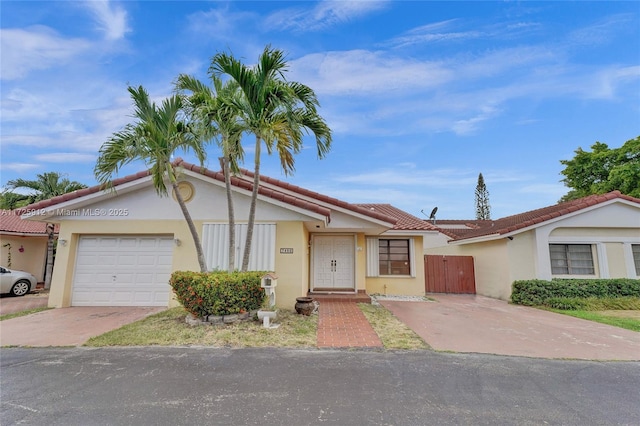 single story home featuring fence, stucco siding, a garage, driveway, and a gate