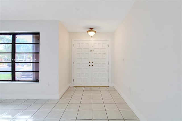 foyer entrance featuring light tile patterned floors and baseboards