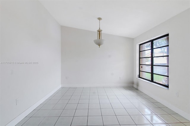 spare room with light tile patterned floors and baseboards