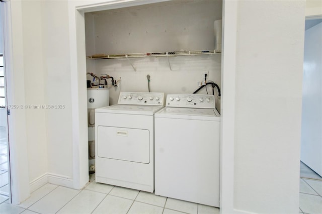 laundry room with washer and clothes dryer, light tile patterned floors, water heater, and laundry area