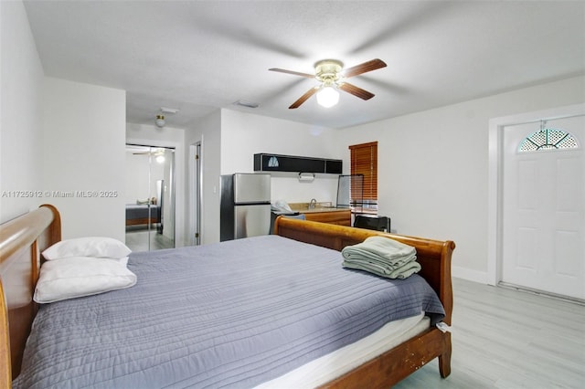 bedroom with visible vents, baseboards, ceiling fan, light wood-style flooring, and freestanding refrigerator