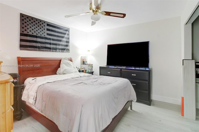 bedroom with light wood-style flooring, baseboards, and ceiling fan