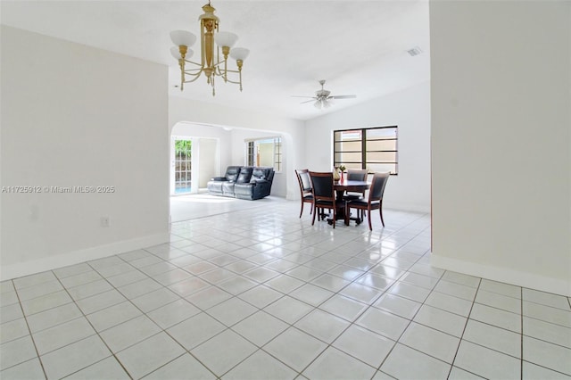 dining room featuring visible vents, baseboards, lofted ceiling, arched walkways, and light tile patterned flooring