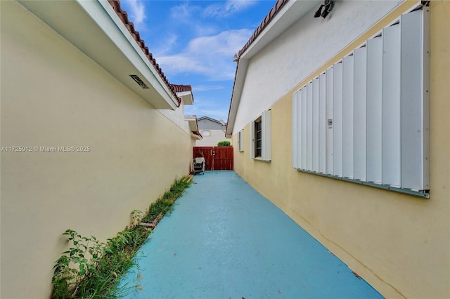 view of property exterior featuring stucco siding and fence