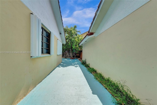 view of home's exterior featuring stucco siding and fence