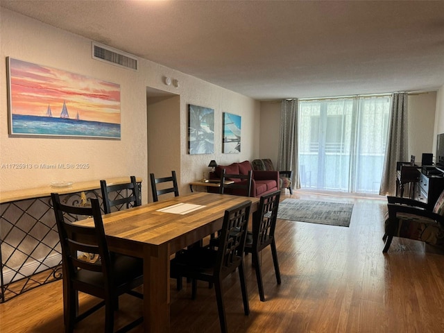 dining room featuring a textured ceiling and hardwood / wood-style floors