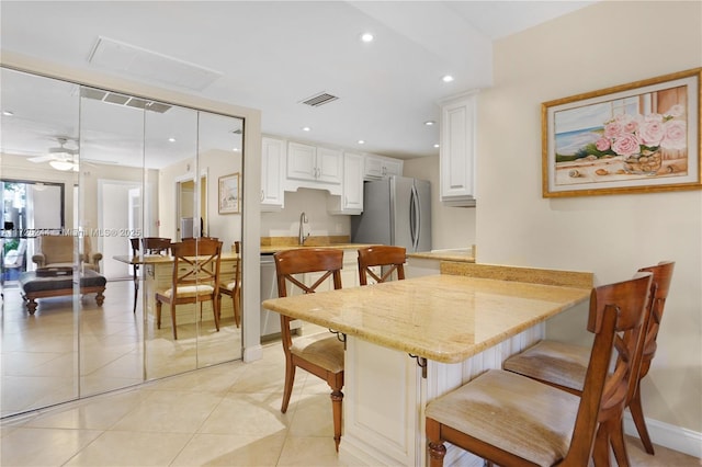 tiled dining area with sink and ceiling fan