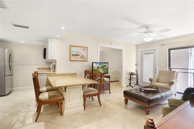 tiled dining space with ceiling fan