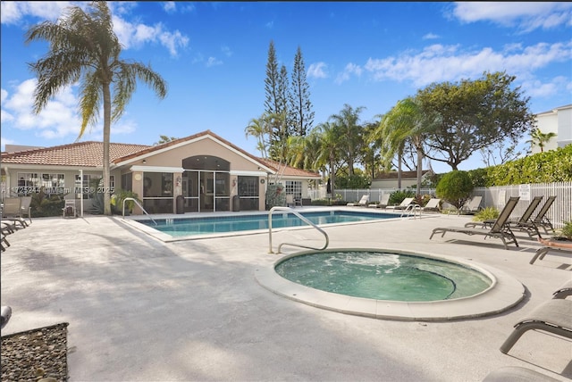 view of swimming pool with a hot tub, a sunroom, and a patio area