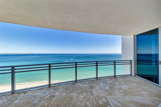 balcony featuring a view of the beach and a water view