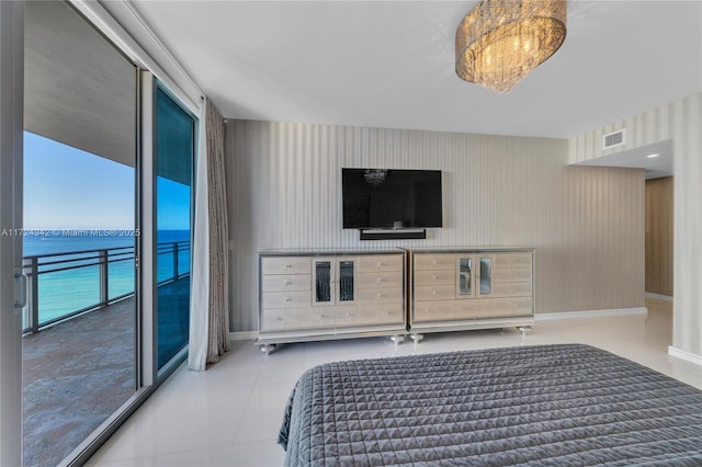 bedroom with access to exterior and a water view