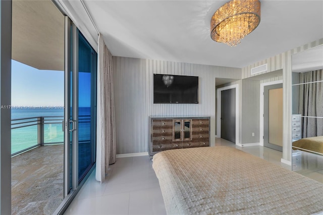 tiled bedroom featuring an inviting chandelier, access to outside, and a water view