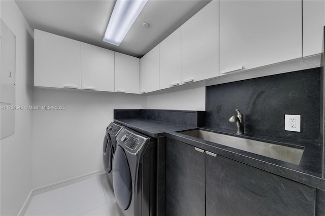 laundry area with light tile patterned flooring, cabinets, washer and clothes dryer, and sink