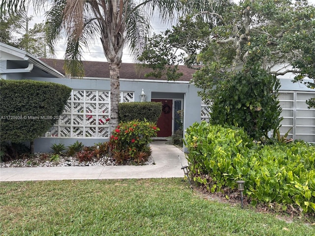 doorway to property with a lawn