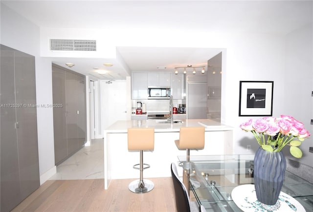 kitchen featuring a breakfast bar area and white cabinetry