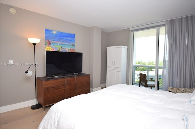 bedroom with access to exterior and light wood-type flooring