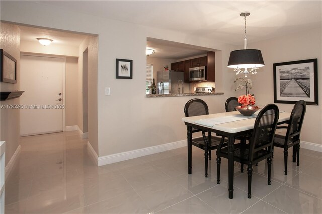 kitchen with appliances with stainless steel finishes, decorative backsplash, light tile patterned flooring, and sink