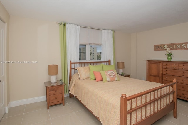 bedroom with baseboards and light tile patterned flooring