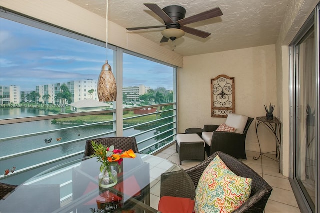 sunroom / solarium with ceiling fan and a city view