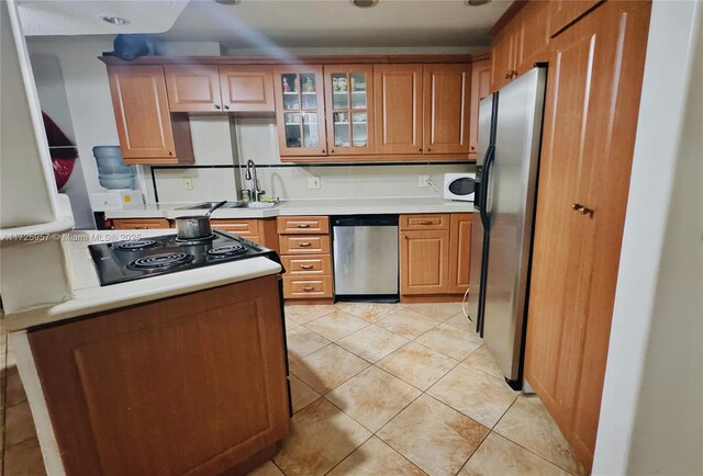 kitchen with a center island, light tile patterned floors, a breakfast bar, sink, and stainless steel dishwasher