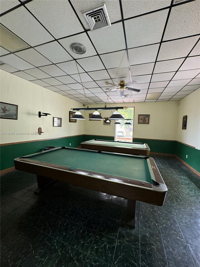 gym with ceiling fan and a paneled ceiling