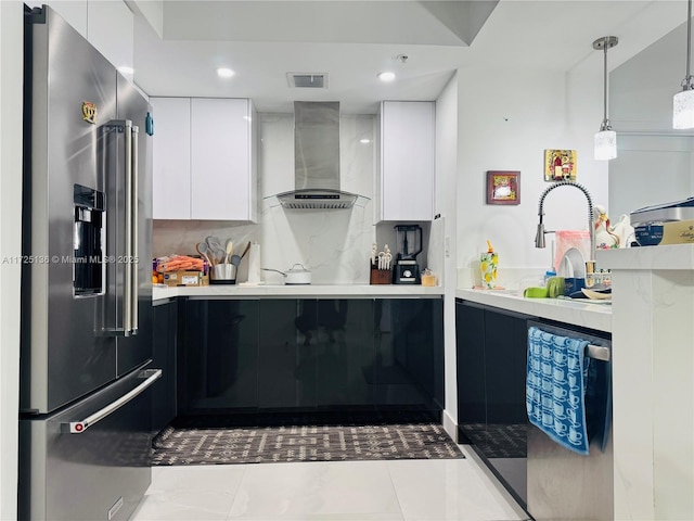 kitchen with white cabinetry, tasteful backsplash, wall chimney range hood, high end refrigerator, and pendant lighting