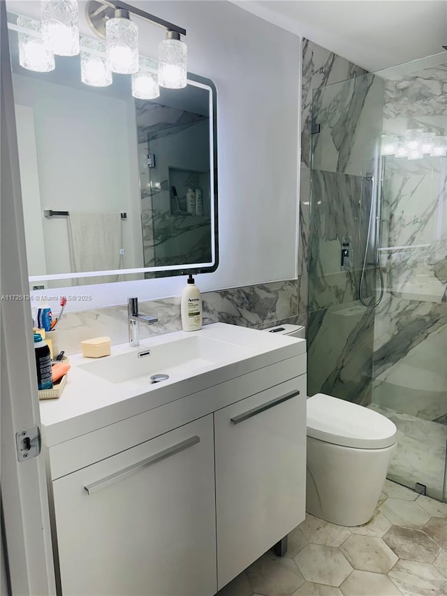 bathroom featuring toilet, a tile shower, vanity, and tile walls