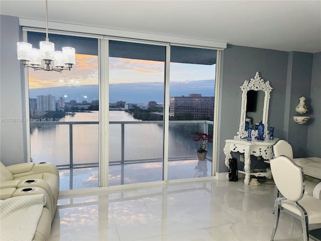 doorway featuring a notable chandelier, a wall of windows, and a water view