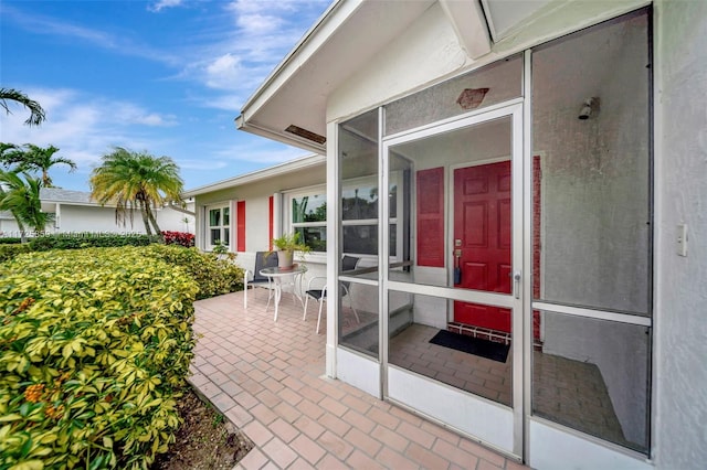 view of exterior entry with a patio area