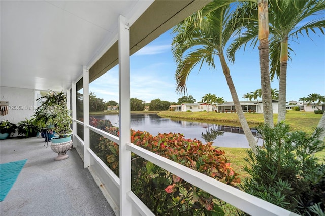 sunroom featuring a water view