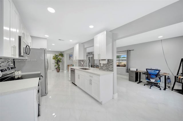 kitchen with stainless steel appliances, white cabinets, sink, and backsplash