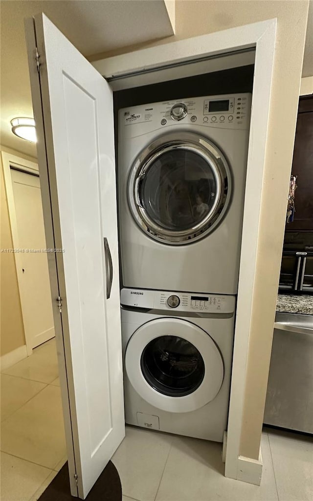 washroom featuring stacked washer / drying machine and light tile patterned floors