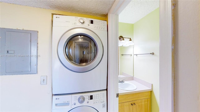 laundry room featuring stacked washer / drying machine, electric panel, sink, and a textured ceiling