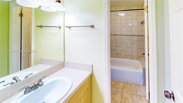 bathroom with tiled shower / bath combo, vanity, and tile patterned flooring