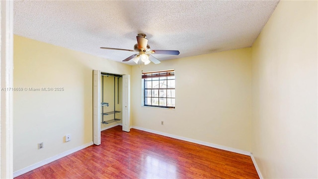 unfurnished bedroom featuring ceiling fan, wood-type flooring, and a textured ceiling