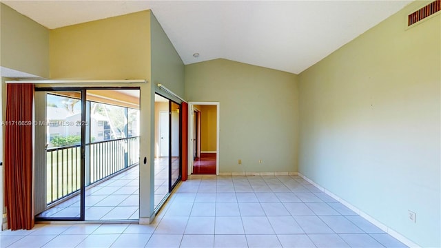 spare room featuring vaulted ceiling and light tile patterned floors