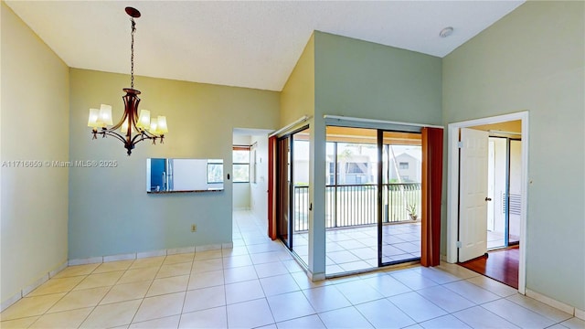 interior space featuring lofted ceiling, light tile patterned floors, and a chandelier