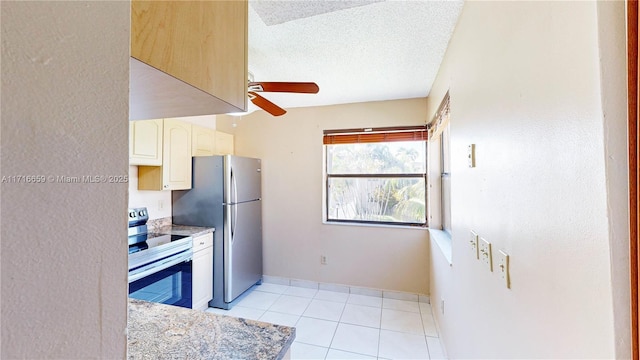 kitchen with light tile patterned flooring, appliances with stainless steel finishes, a textured ceiling, and ceiling fan