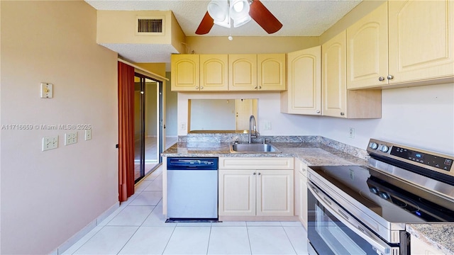 kitchen featuring light tile patterned flooring, stainless steel appliances, sink, and a textured ceiling