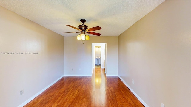 unfurnished room with ceiling fan, hardwood / wood-style flooring, and a textured ceiling