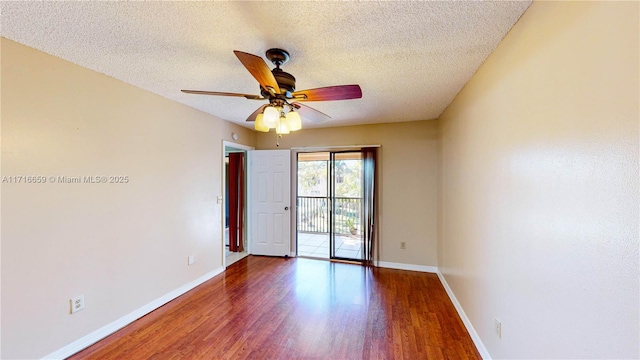 empty room with ceiling fan, dark hardwood / wood-style floors, and a textured ceiling