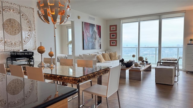 dining area with a wall of windows, a water view, and dark wood-type flooring