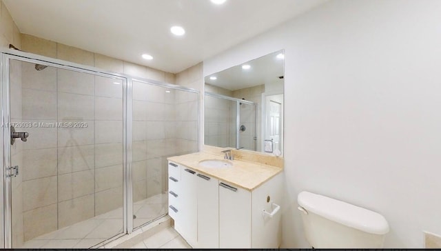 bathroom featuring toilet, tile patterned flooring, walk in shower, and vanity