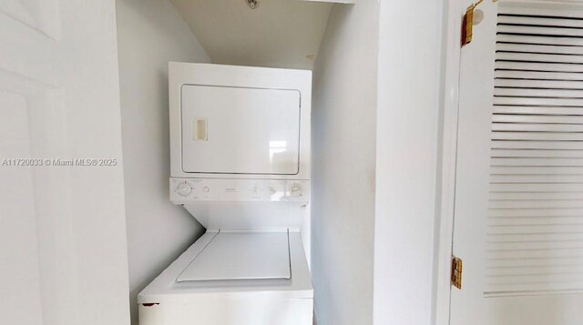 clothes washing area with stacked washing maching and dryer