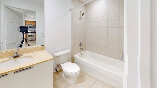 full bathroom featuring toilet, vanity, tile patterned floors, and tiled shower / bath