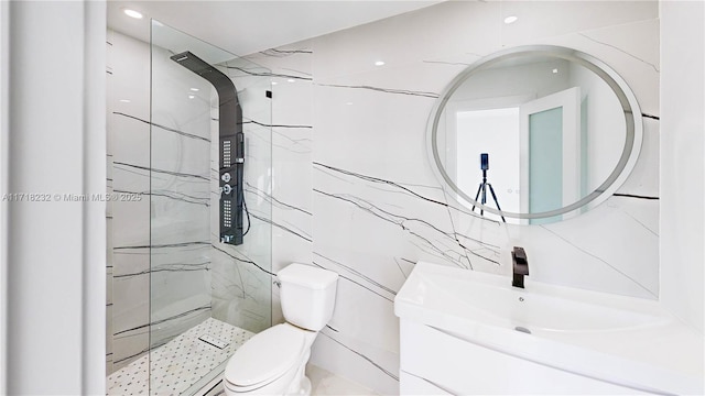 bathroom with vanity, toilet, tile walls, and a tile shower